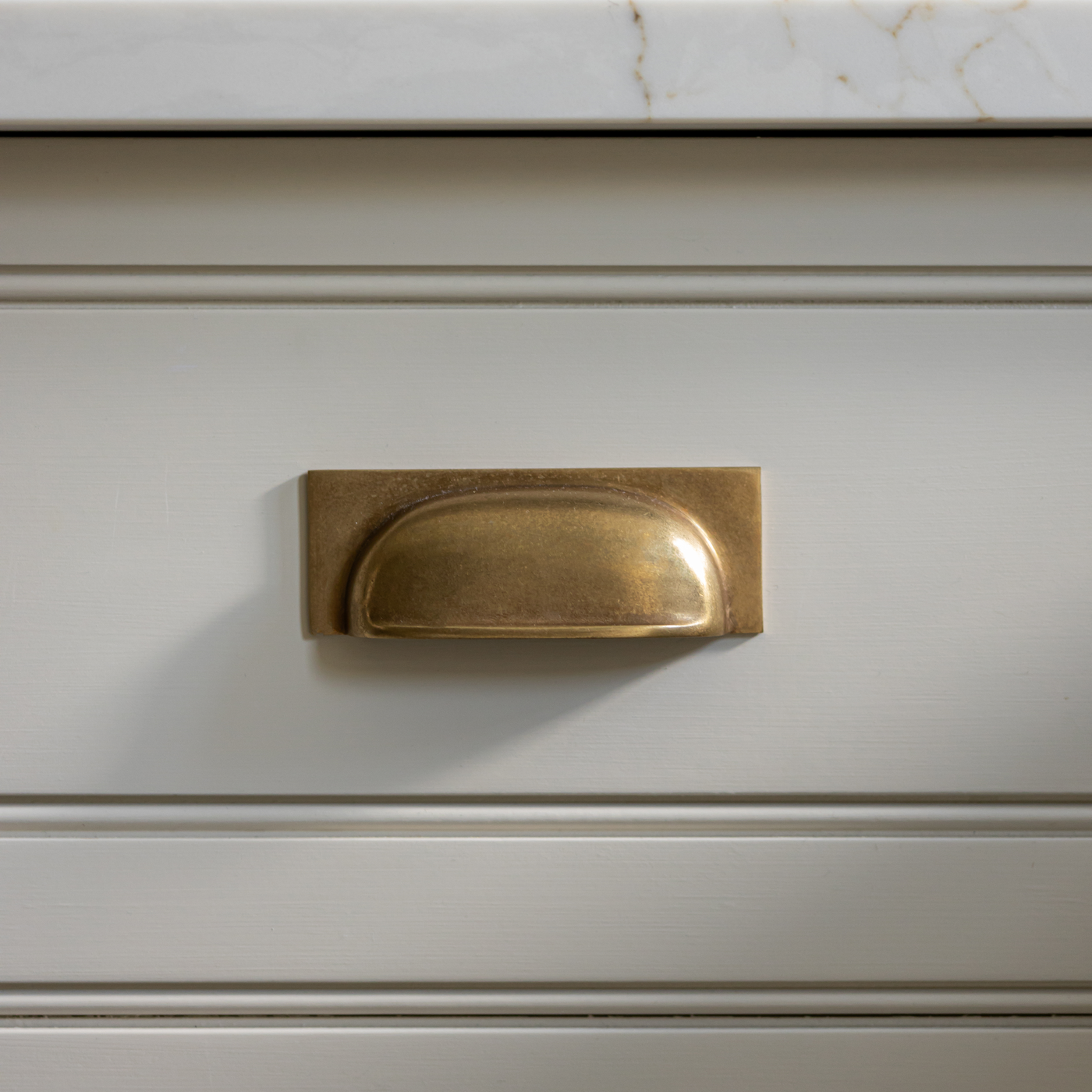 Queslett Cup-handtag — Antik mässing. Design by Rachael Somerville Interiors.